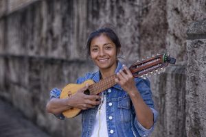 joven ense&ntilde;ando como tocar un charango