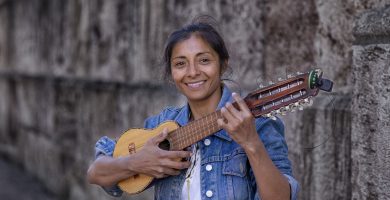joven ense&ntilde;ando como tocar un charango