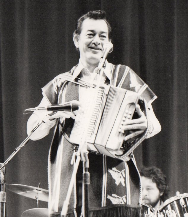 Flaco Jiménez tocando un acordeón diatónico de botones en un concierto de música tex-mex