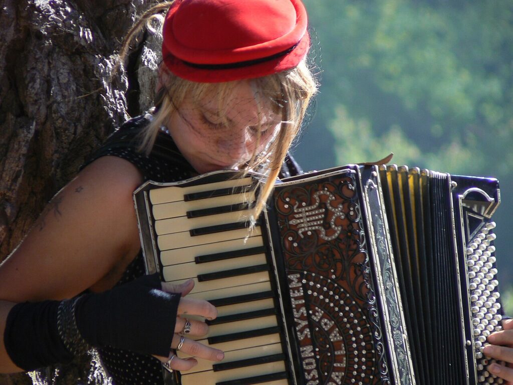 Acordeonista tocando: la mano derecha sobre el teclado de piano y la izquierda sobre la botonera de bajos
