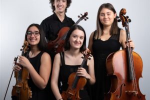 Cuatro jóvenes músicos posan con dos violines, una viola y un violonchelo, que muestran la diferencia de tamaño